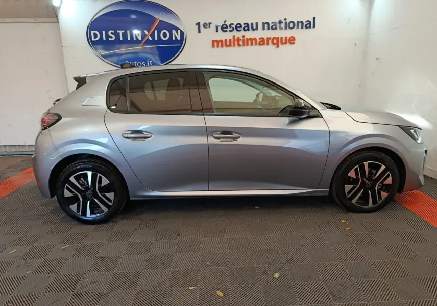 Peugeot 208 PureTech 100 S&S Allure gris clair vue de profil côté gauche en intérieur showroom.