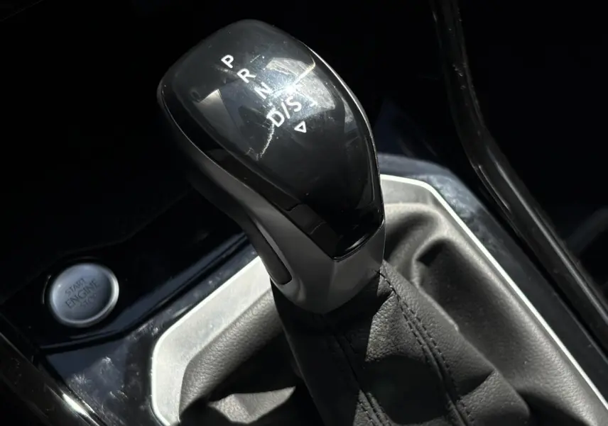 Gros plan sur le levier de vitesse automatique noir et argenté du Volkswagen T-Roc 2025, bouton start visible à gauche.