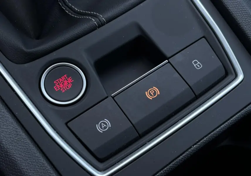 Gros plan sur la console centrale de la SEAT LEON ST 1.5 TSI 115 Style, boutons start/stop et frein électrique visibles.