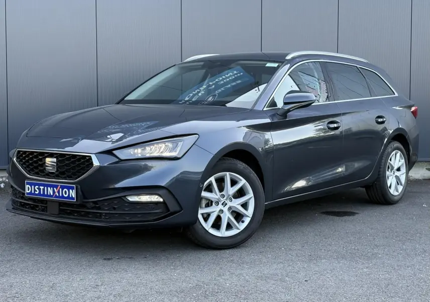 SEAT LEON ST gris magnétique en 3/4 avant droit, jantes alliage 16 pouces et vitres arrière surteintées visibles.