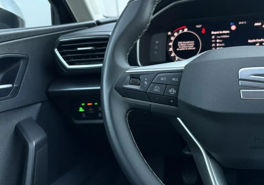 Gros plan sur le volant cuir multifonction et le tableau de bord numérique de la SEAT LEON ST 2025.