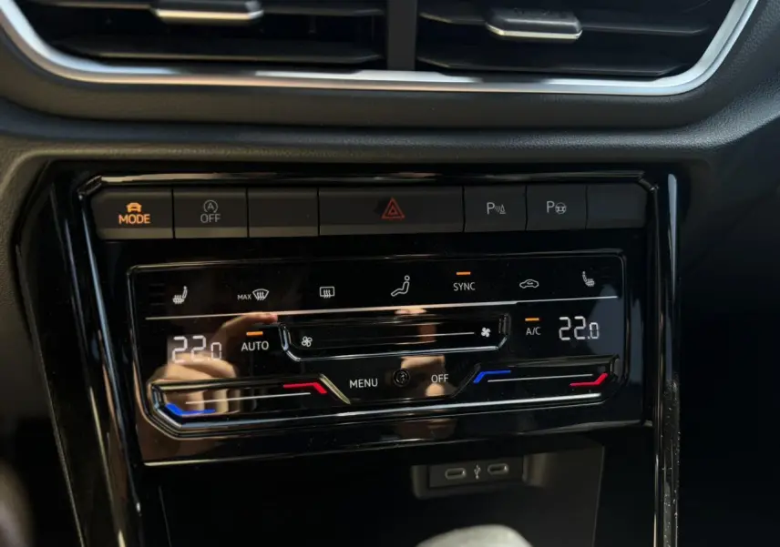 Vue rapprochée de la console centrale du Volkswagen T-Roc 2025, affichant la climatisation automatique bi-zone et ports USB-C.