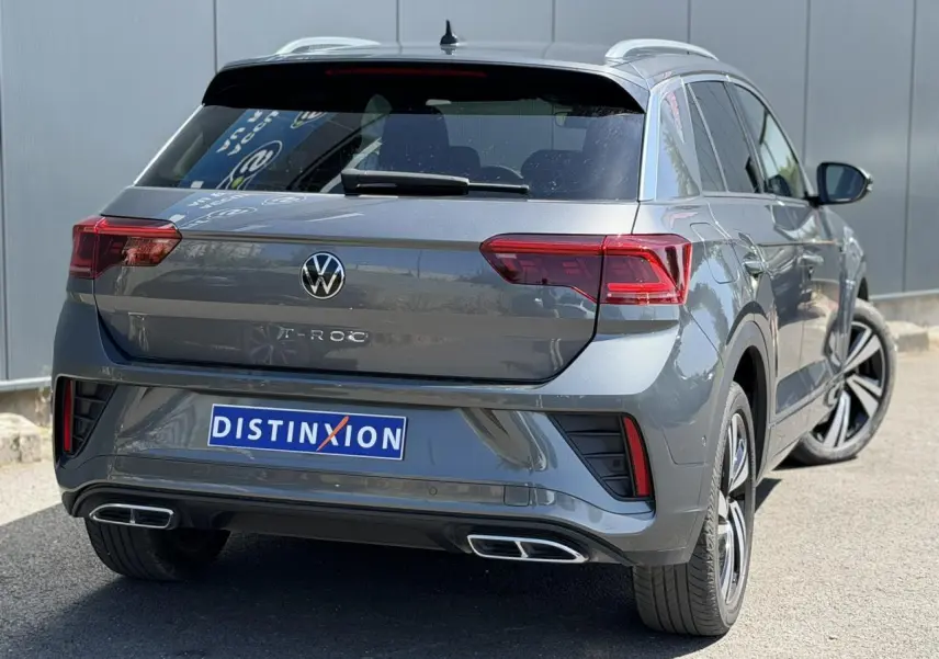 Vue 3/4 arrière droite du Volkswagen T-Roc gris Indium avec feux Matrix LED et double sorties d’échappement rectangulaires.
