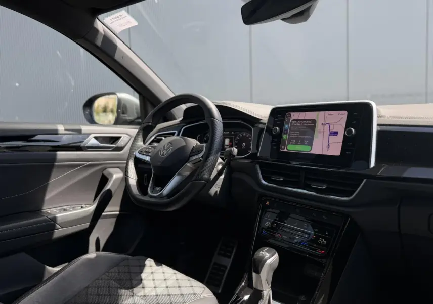 Vue intérieure côté conducteur du Volkswagen T-Roc 1.5 TSI R-Line avec volant cuir, écran tactile 8 pouces et tableau de bord digital.