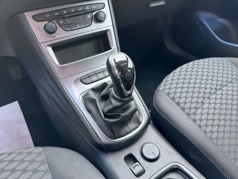 Vue rapprochée de la console centrale de l'Opel Astra Sports Tourer 2021 avec levier de vitesses manuel et sièges tissu noir à motifs.