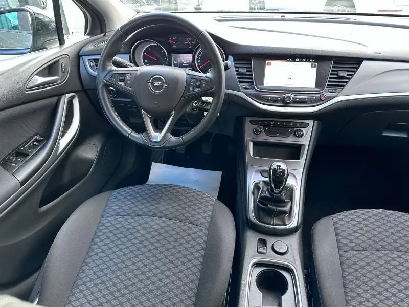 Intérieur de l'Opel Astra Sports Tourer 2021, vue de face sur le volant cuir, tableau de bord et levier de vitesses manuelle.