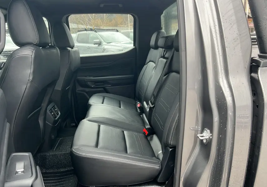 Vue intérieure côté droit sur les sièges arrière en cuir noir du Ford Ranger 2025, version Tremor Cover.