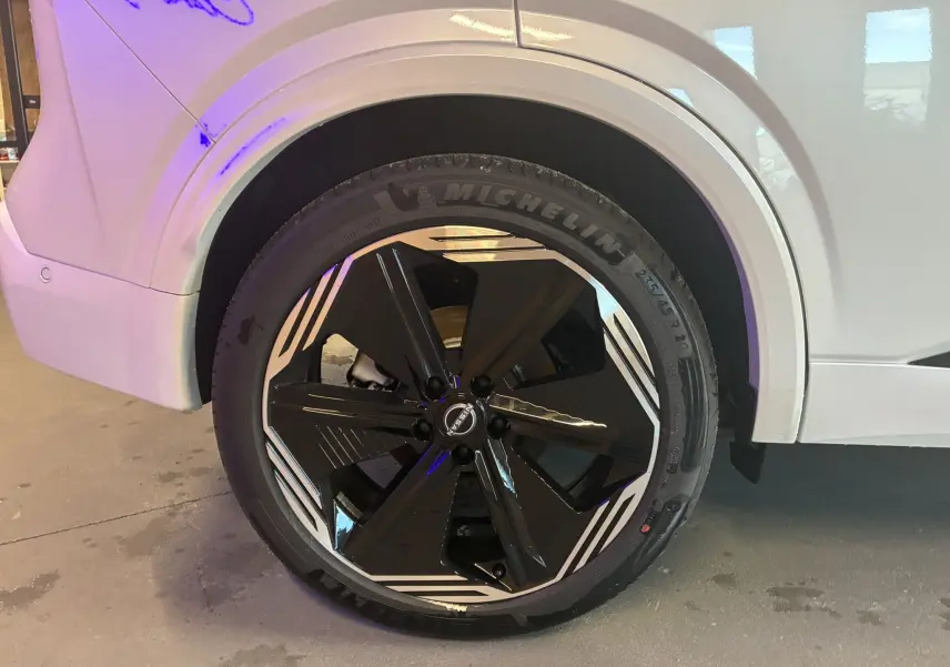 Gros plan sur la roue avant gauche du Nissan Qashqai blanc nacré avec jante noire et détails argentés design 2025.