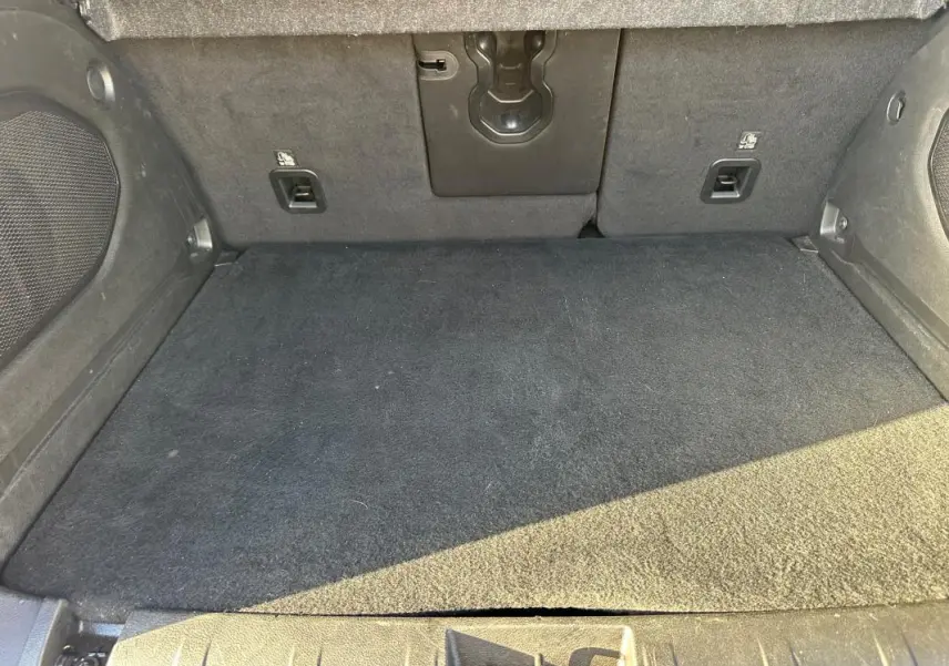 Vue intérieure du coffre noir du Jeep Renegade 2022, montrant le tapis et les fixations arrière.