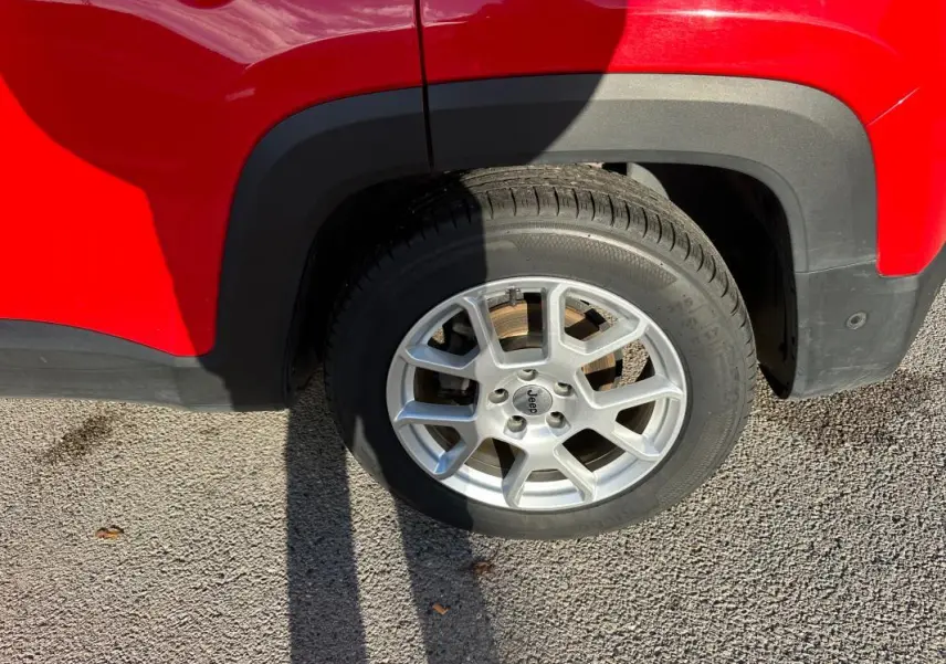 Gros plan sur la roue avant droite du Jeep Renegade rouge 2022 avec jante alliage 17 pouces.