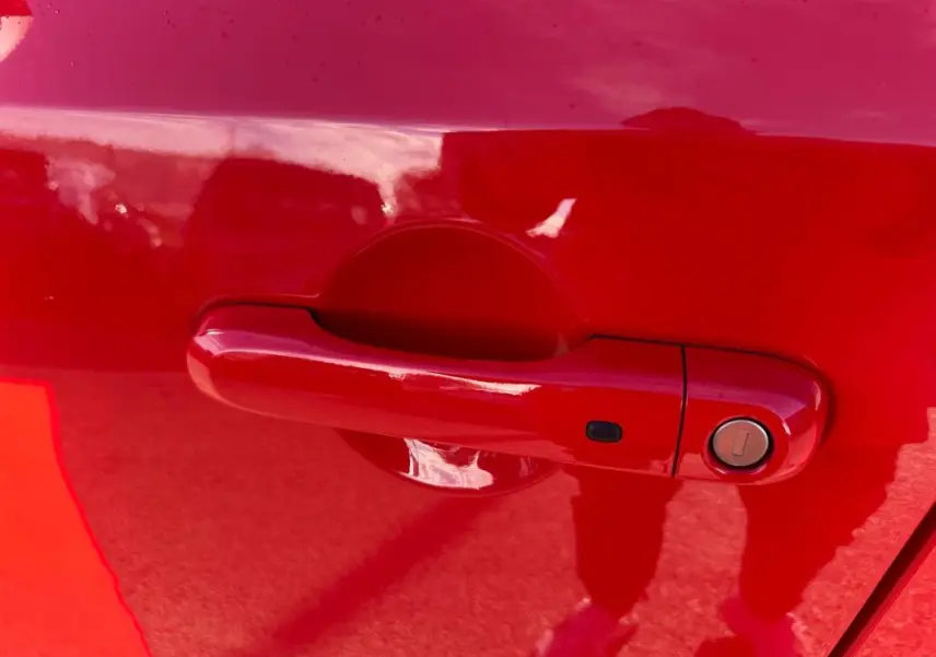 Poignée de porte rouge en gros plan sur une Jeep Renegade 2022, finition Limited diesel.