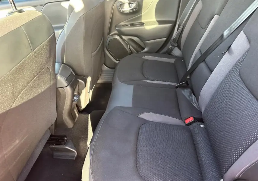 Vue intérieure arrière côté droit du Jeep Renegade 2022, sièges tissu gris foncé avec ceinture de sécurité visible.