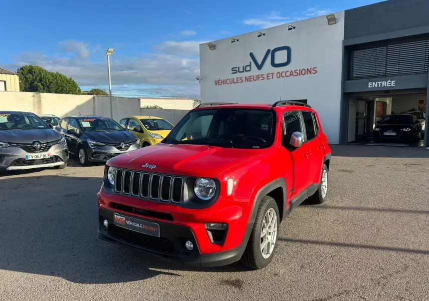 Jeep Renegade rouge vue 3/4 avant droit avec jantes alliage 17 pouces, stationné devant un concessionnaire.