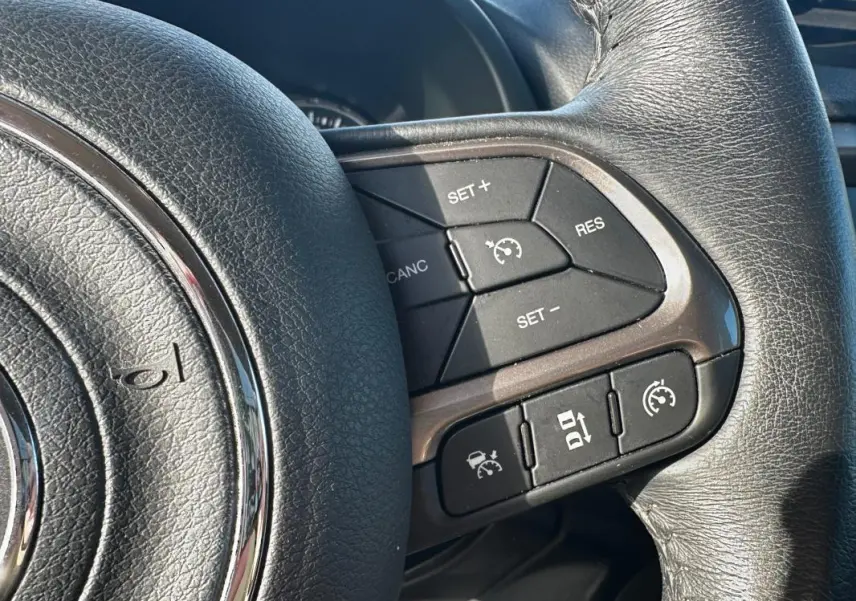 Gros plan sur le volant noir de la Jeep Renegade 2022, montrant les commandes du régulateur de vitesse.