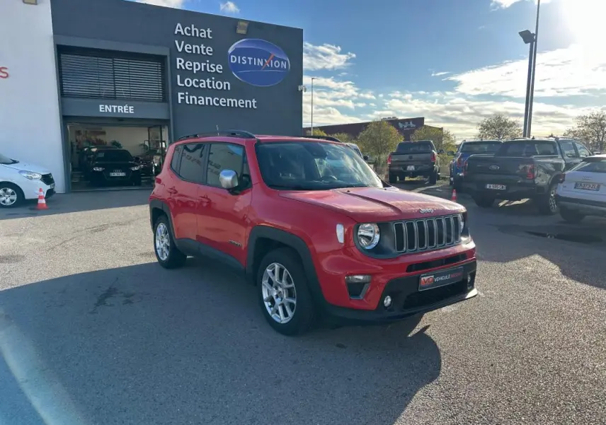 Jeep Renegade rouge vue 3/4 avant droit avec jantes alliage 17 pouces, stationné devant un garage.