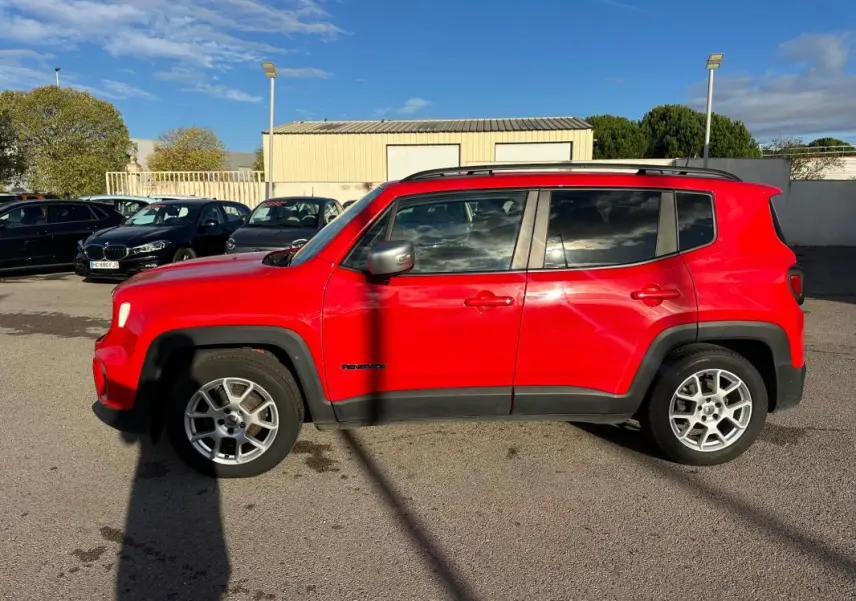 Profil côté gauche d'un Jeep Renegade rouge 2022 avec jantes alliage 17 pouces et barres de toit noires.