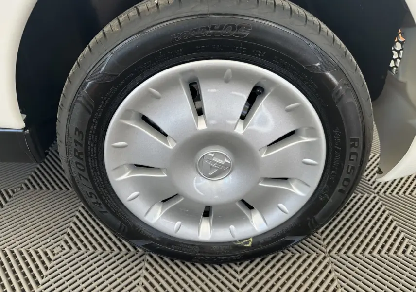 Gros plan sur la roue avant gauche blanche d'une Aixam Ambition E City Pack 2025 avec enjoliveur et pneu Roadhog.