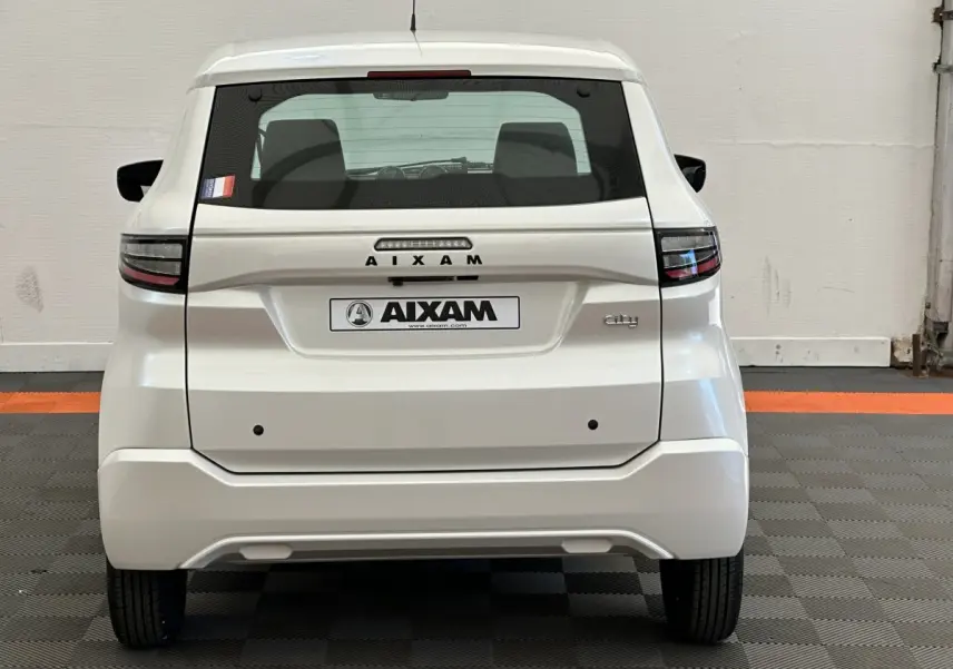 Vue arrière d'une Aixam Ambition E City Pack blanche 2025 avec feux LED et logo distinctif sur fond neutre.