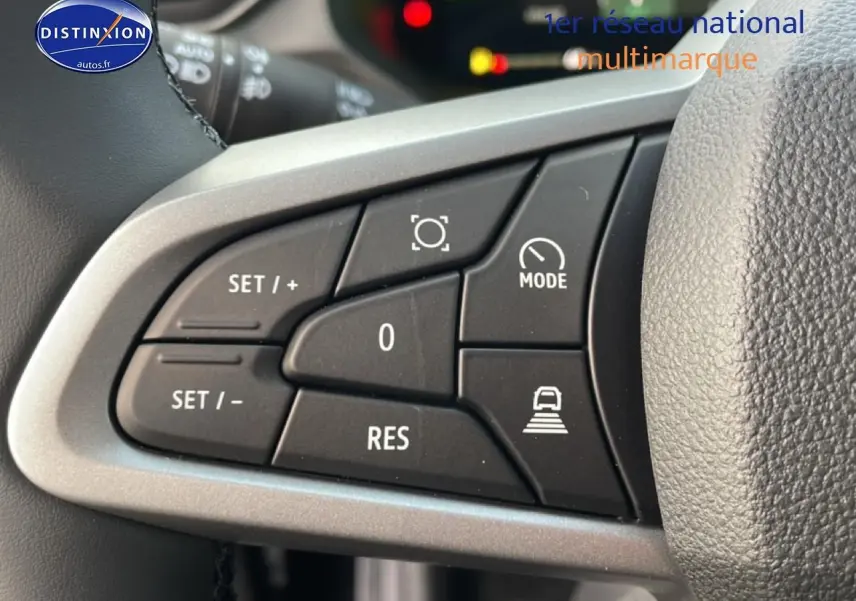 Gros plan sur les commandes au volant du Dacia Bigster gris schiste, mettant en valeur les boutons de régulateur et mode de conduite.