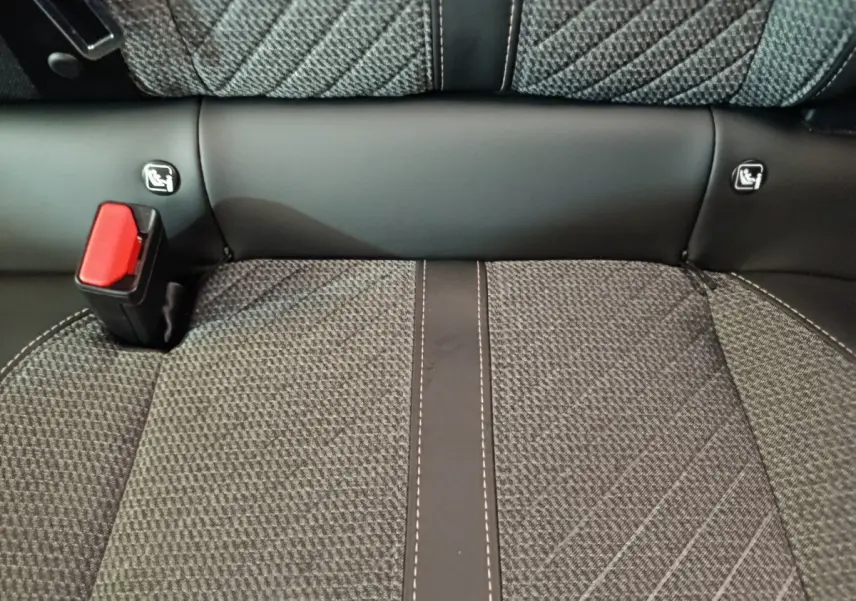 Gros plan sur la banquette arrière grise avec coutures contrastées et attaches Isofix visibles sur une Peugeot 208.