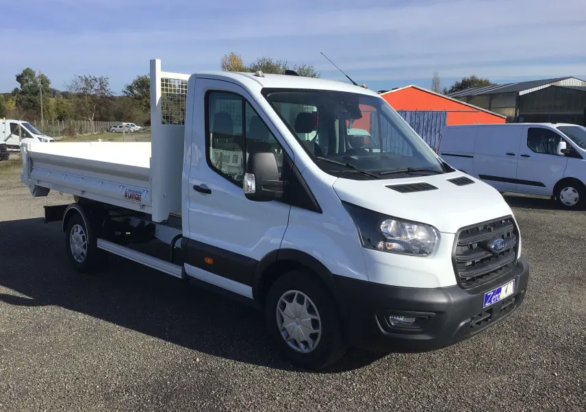 Ford Transit Chassis cabine blanc vu en 3/4 avant droit avec benne et bras de levage sur parking extérieur.