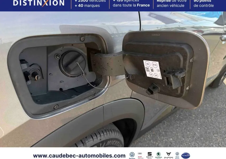 Trappe à carburant ouverte côté gauche sur Renault Symbioz gris métallisé, détail de la bouchon essence hybride.