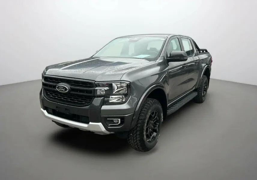 Ford Ranger 2025 gris carbone en 3/4 avant droit, avec calandre noire et pneus tout-terrain marqués Tremor.