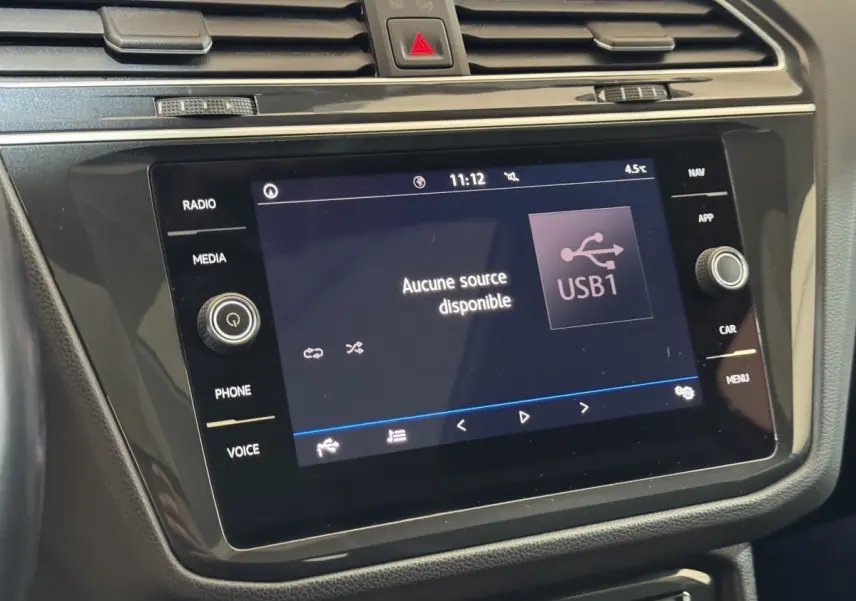 Écran tactile central du Volkswagen Tiguan blanc 2020 affichant "Aucune source disponible" en intérieur.