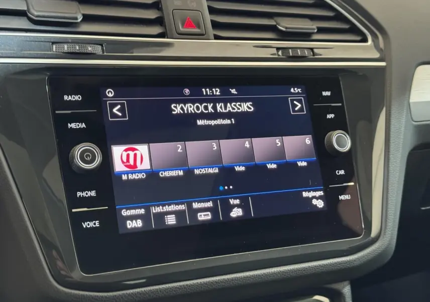 Écran tactile central du Volkswagen Tiguan blanc 2020 affichant la radio Skyrock Klassiks en intérieur voiture.