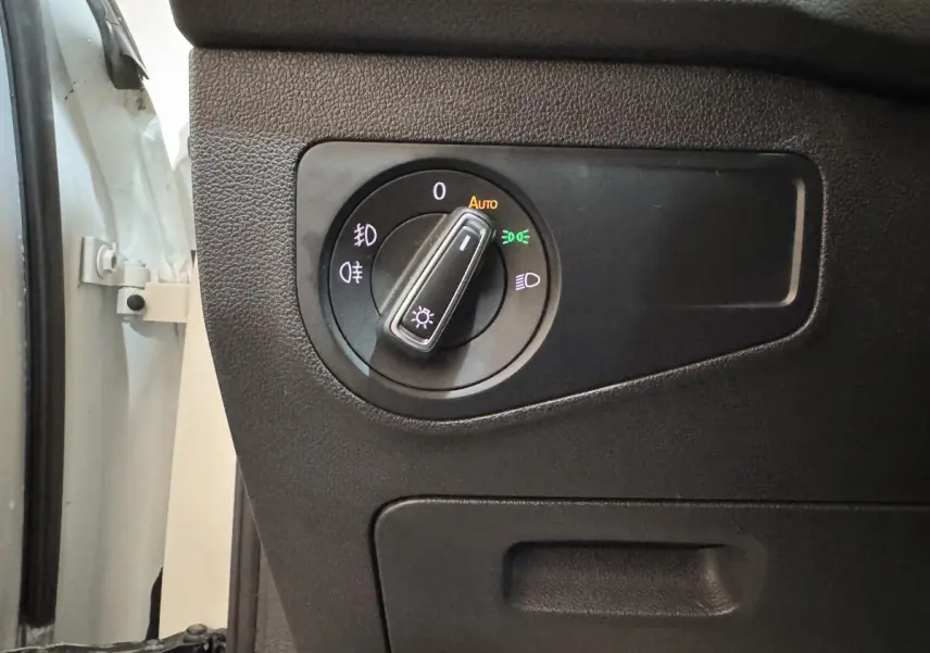 Gros plan sur la commande des phares à gauche du tableau de bord d'un Volkswagen Tiguan blanc 2020.