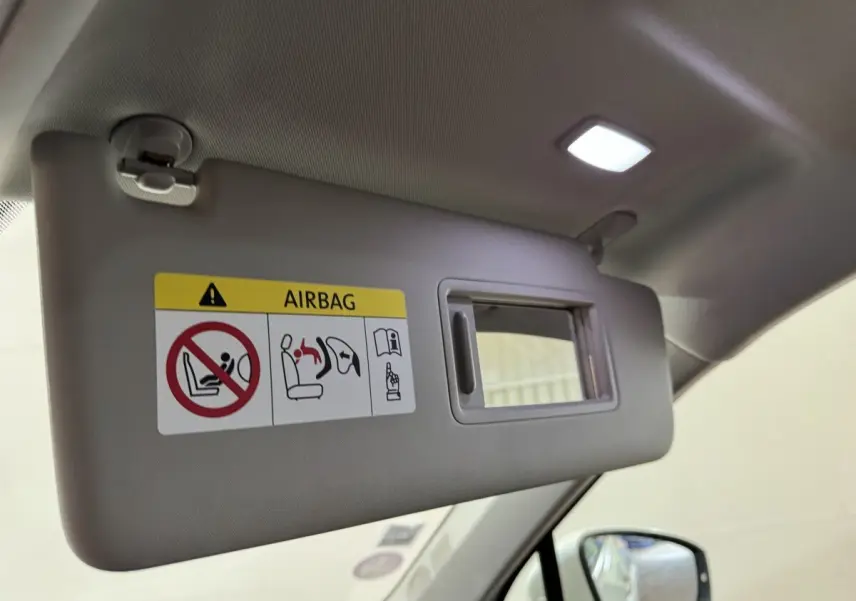 Détail du pare-soleil côté conducteur avec miroir et avertissement airbag dans un Volkswagen Tiguan blanc 2020.