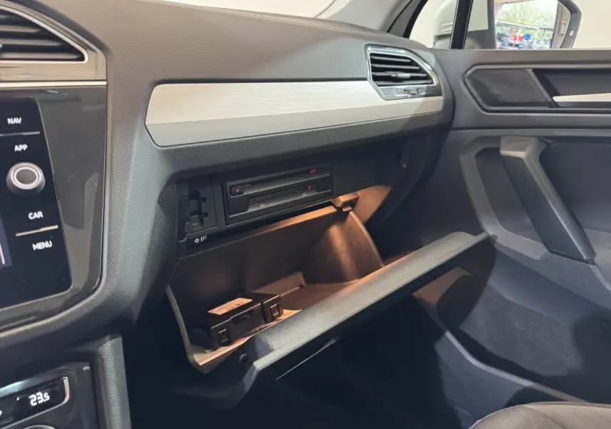 Intérieur du Volkswagen Tiguan 1.5 TSI 2020, vue sur la boîte à gants ouverte côté passager avec tableau de bord gris.