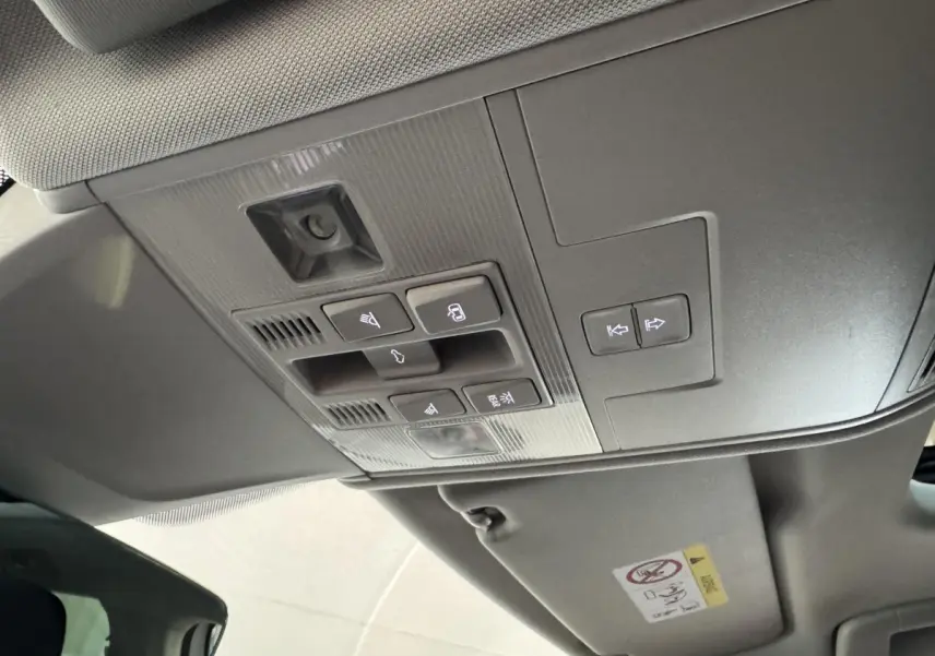 Vue en contre-plongée du plafonnier gris avec commandes d'éclairage et ouverture du coffre du Volkswagen Tiguan blanc 2020.