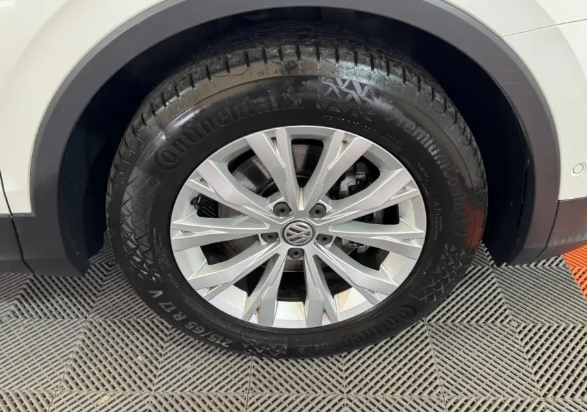 Gros plan sur la roue arrière droite du Volkswagen Tiguan blanc, avec jante alliage et pneu Continental.