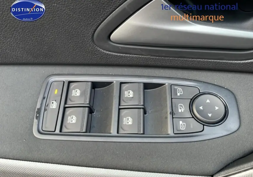 Vue rapprochée des commandes de lève-vitres et rétroviseurs sur la porte côté gauche d’un Dacia Bigster gris schiste.