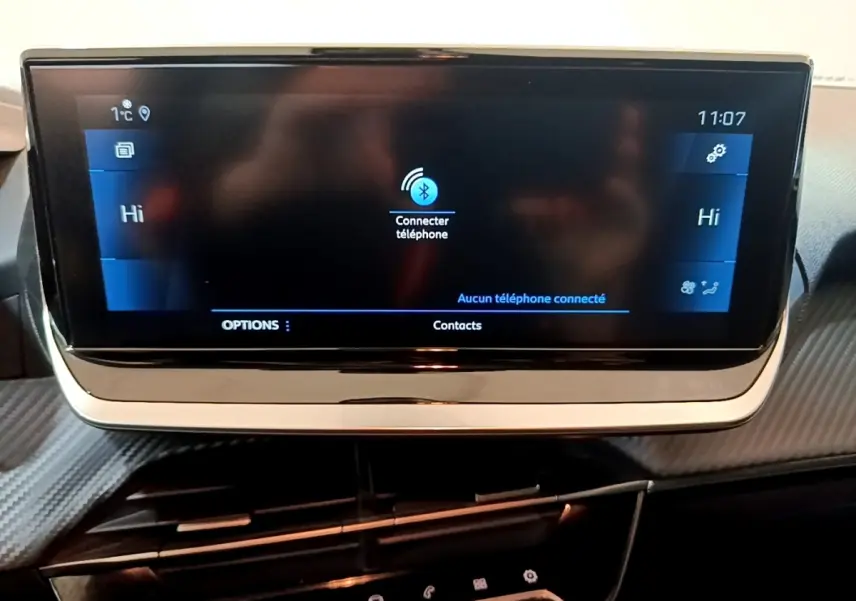 Écran tactile central 17,8 cm du tableau de bord de la Peugeot 208 jaune, affichant la connexion Bluetooth.