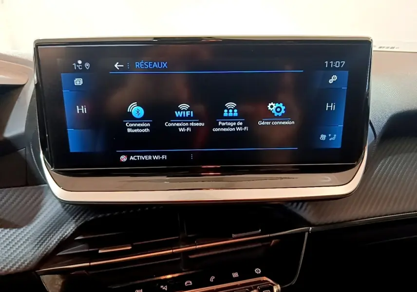 Écran tactile central de la Peugeot 208 jaune, affichant les options de connexion Bluetooth et Wi-Fi.