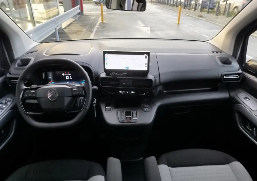 Vue intérieure avant du Citroën Berlingo gris acier 2025, avec tableau de bord numérique et écran tactile central.