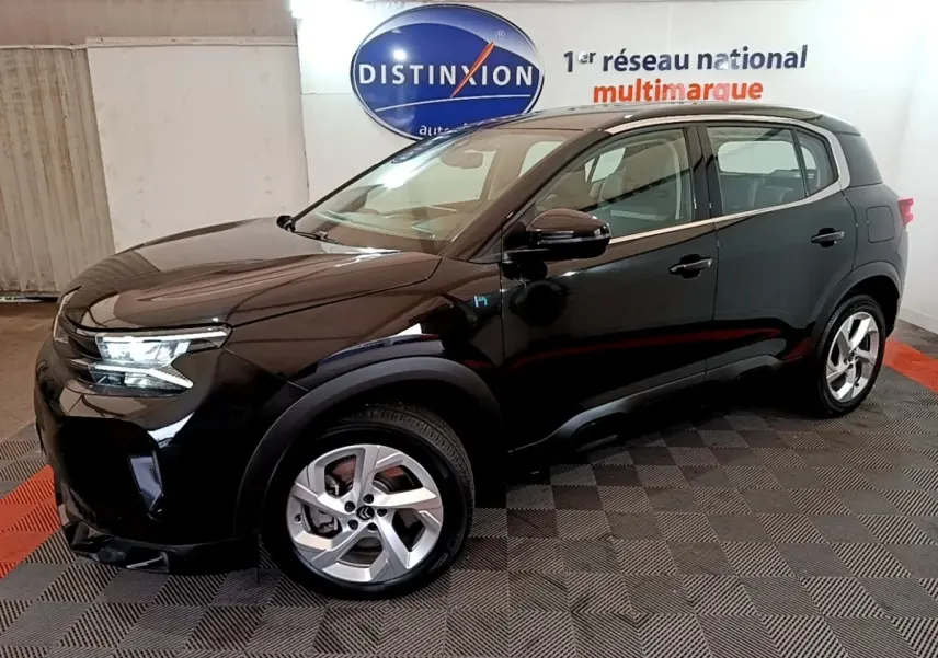 Vue 3/4 avant droit d’un Citroën C5 Aircross hybride rechargeable noir, avec jantes alliage et logo H bleu sur aile.