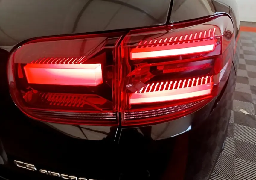 Gros plan sur le feu arrière droit rouge d’un Citroën C5 Aircross noir, avec logo visible sur la carrosserie.