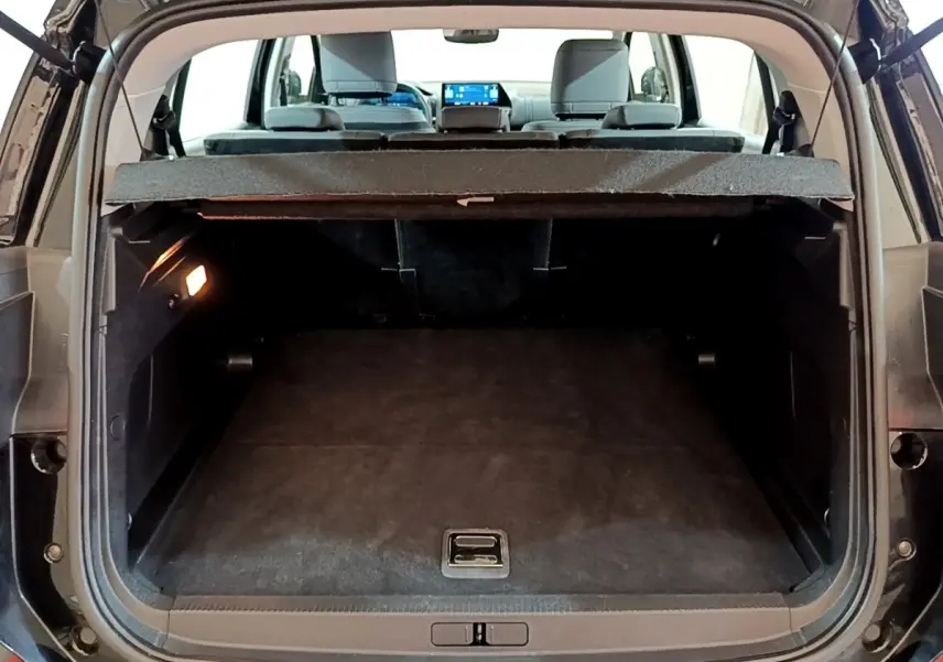 Vue arrière du coffre ouvert d’un Citroën C5 Aircross hybride rechargeable noir, montrant l’espace de chargement vide et la tablette cache-bagages.