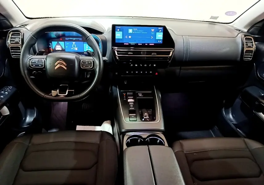 Intérieur noir du Citroën C5 Aircross hybride rechargeable vu de face, avec tableau de bord digital et écran tactile central.