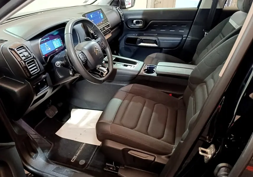 Vue intérieure côté conducteur du Citroën C5 Aircross hybride rechargeable noir, avec tableau de bord digital et sièges noirs.