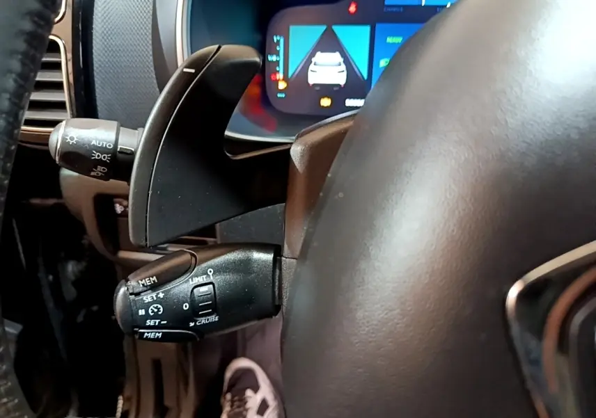 Gros plan sur la commande de régulateur de vitesse et levier de clignotant du tableau de bord noir du Citroën C5 Aircross hybride.