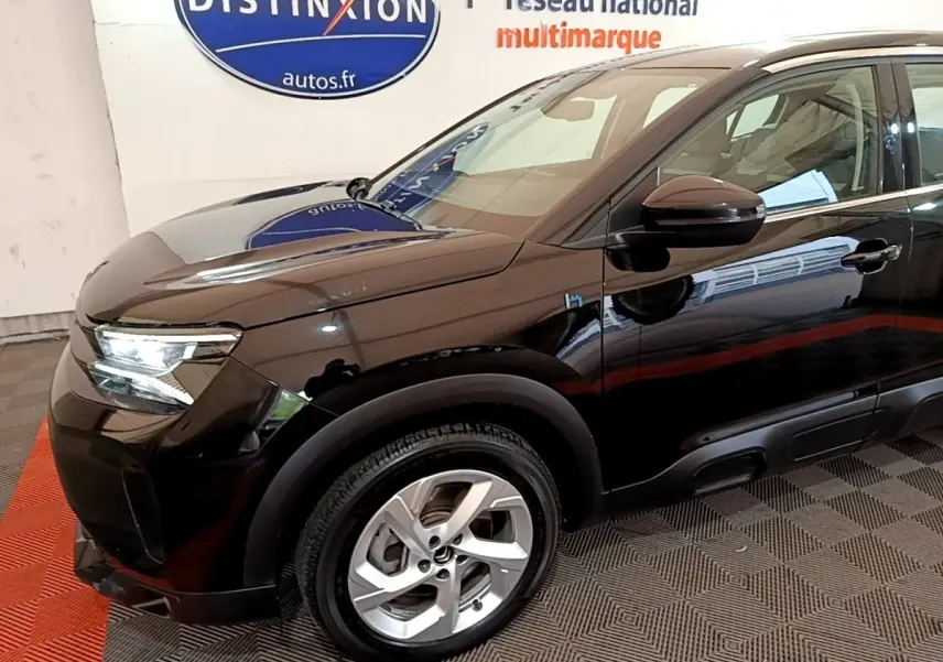 Vue 3/4 avant côté gauche d’un Citroën C5 Aircross hybride rechargeable noir brillant avec jantes argentées.