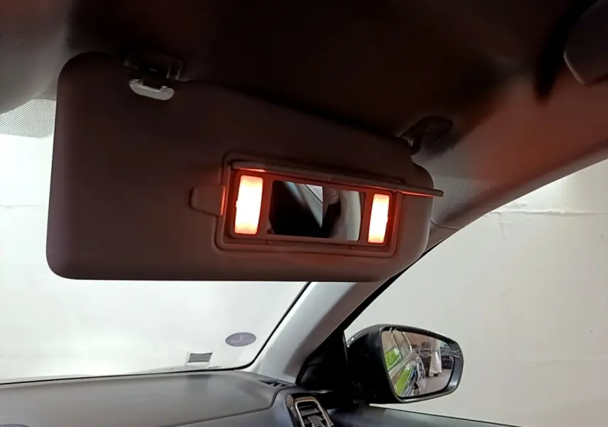 Intérieur du Citroën C5 Aircross hybride noir, vue côté passager avec pare-soleil et miroir éclairé.