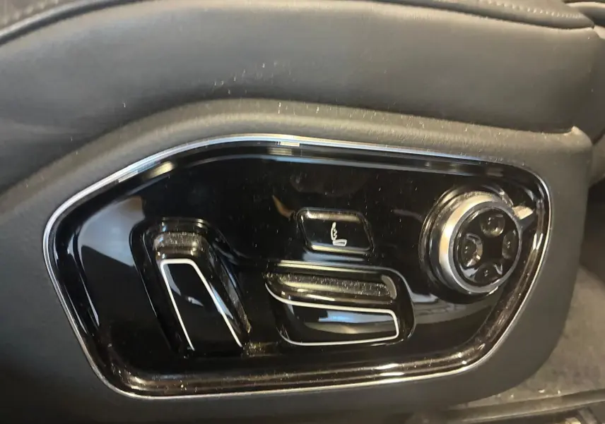 Gros plan sur les commandes de réglage électrique du siège côté gauche d'une Audi A8 noire 2016.