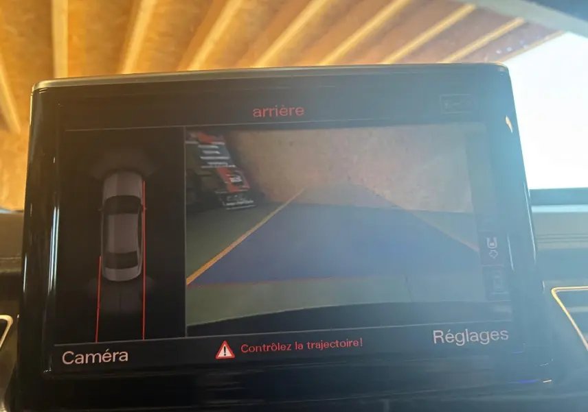 Écran de caméra de recul dans une Audi A8 noire 2016, affichant la vue arrière avec guidage de trajectoire.