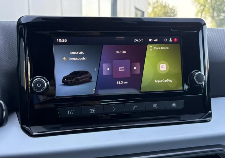 Écran tactile central de la SEAT Ibiza TSI 115 Xcellence affichant radio FM/DAB et Apple CarPlay, intérieur noir.