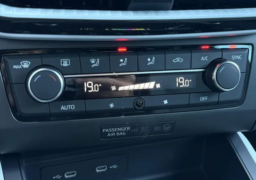 Gros plan sur la commande de climatisation bi-zone noire avec affichage digital à 19°C dans une SEAT Ibiza gris magnétique.